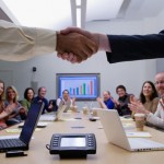 Corporate hand shaking over table